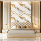 Luxury modern bedroom featuring a white and gold marble accent wall, upholstered cream bed, warm gold lighting, and elegant contemporary interior styling.